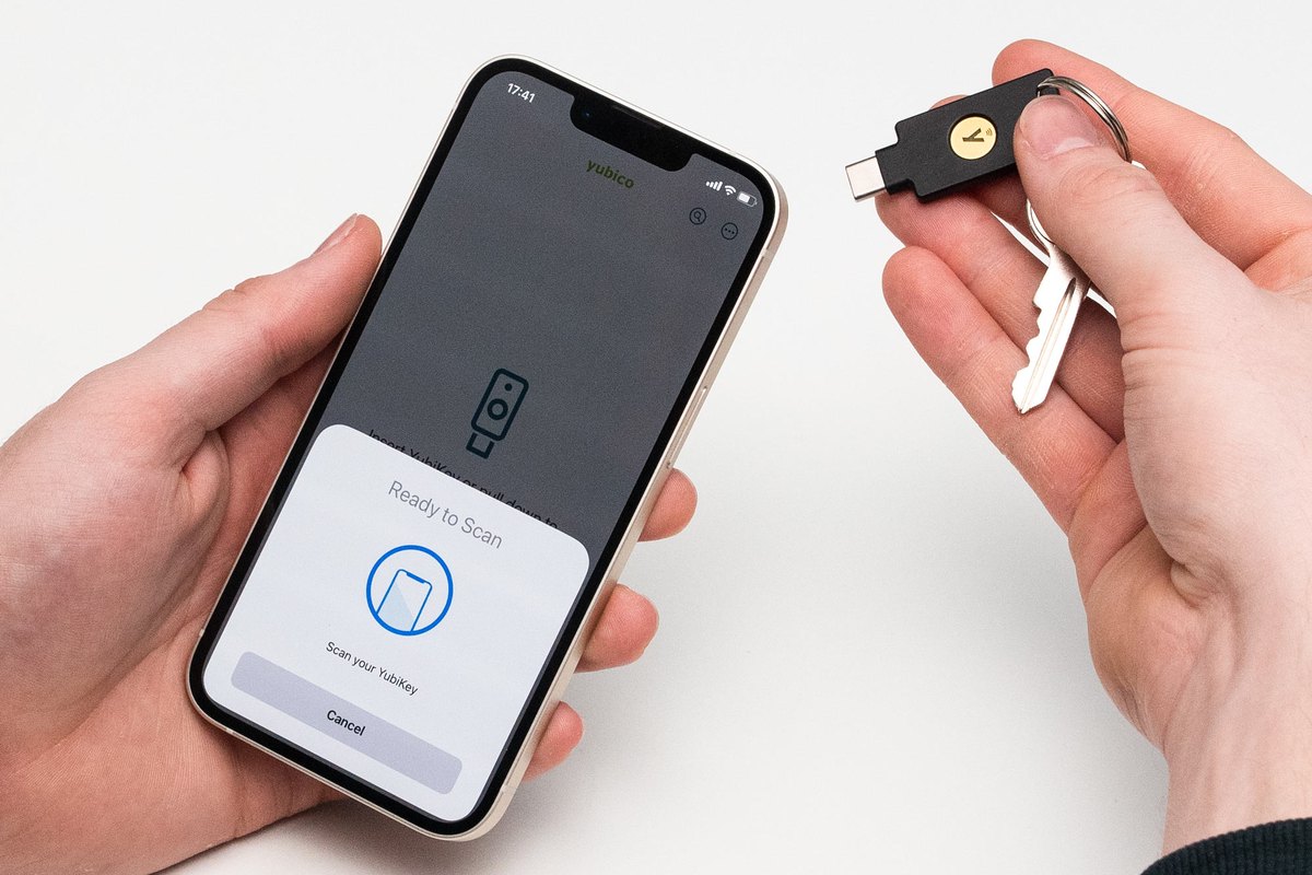 Person tapping a YubiKey 5C NFC on a keyring to an iPhone to sign in